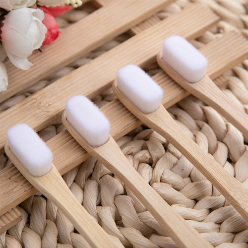 Set of wooden toothbrushes with white bristles on a woven surface
