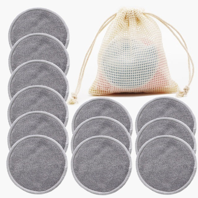 Set of gray reusable makeup pads with a mesh storage bag on a white background