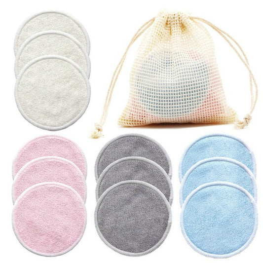 Set of reusable makeup remover pads in gray, pink, and blue with a mesh storage bag on a white background.